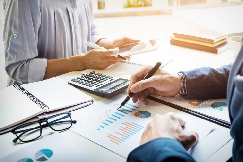 A tax professional reviews financial documents with a client during an individual tax planning consultation.
