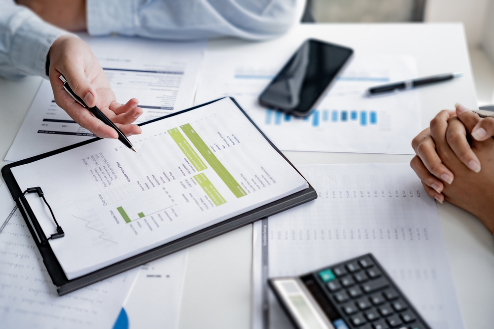 A tax professional reviews financial documents with a client during a tax accounting consultation.