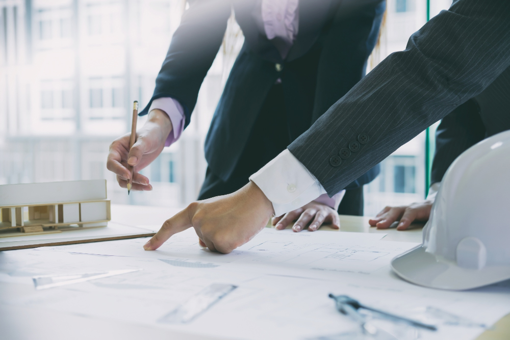 Business professionals review plans and documents during a succession planning meeting.