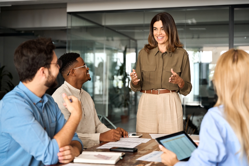 A business leader presents to colleagues during a management consulting meeting.